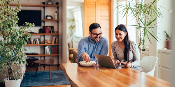 couple sitting at table looking at computer researching fla home loans