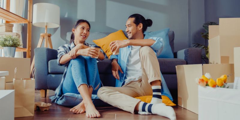 couple sitting in living room with moving boxes