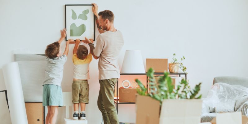 family hanging up pictures on wall